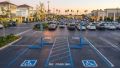 Accessible parking area at a commercial property with marked access aisle, parking signs, and a curb ramp connection